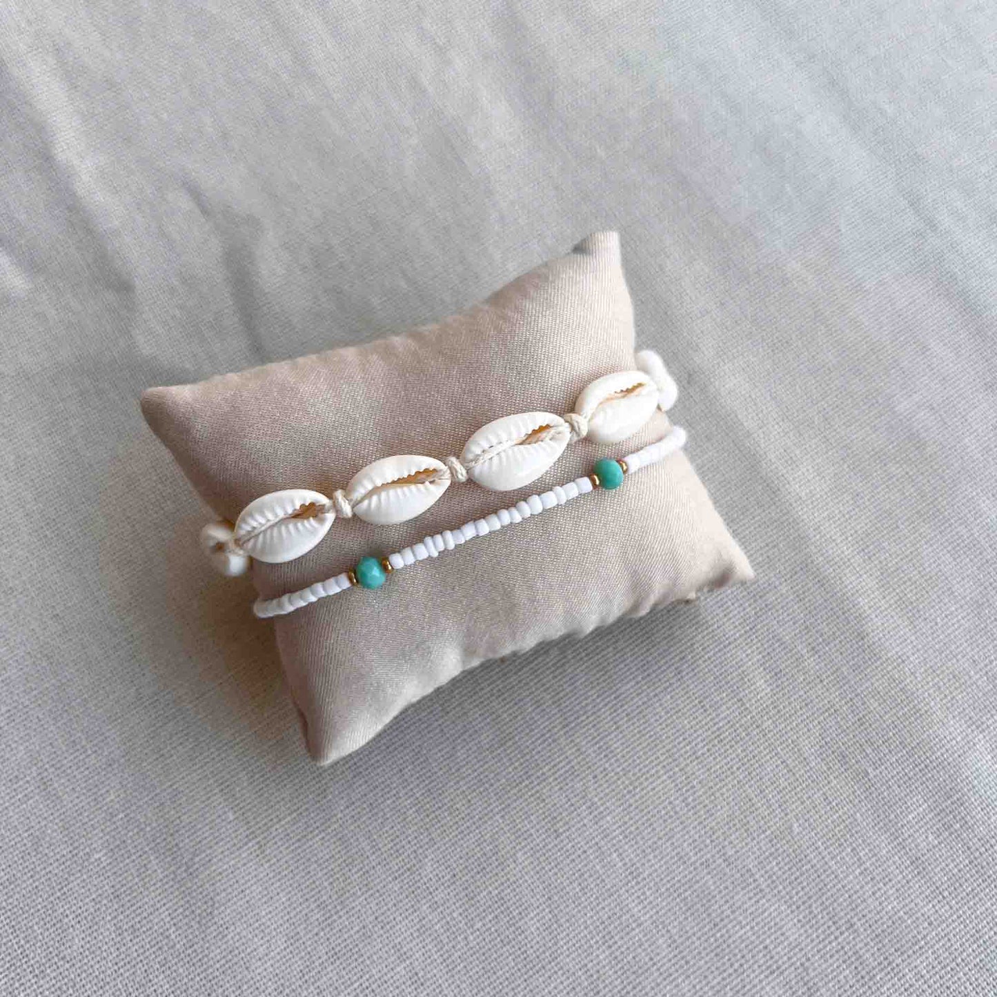 Lichtgekleurd armbandje met kralen om een kussentje