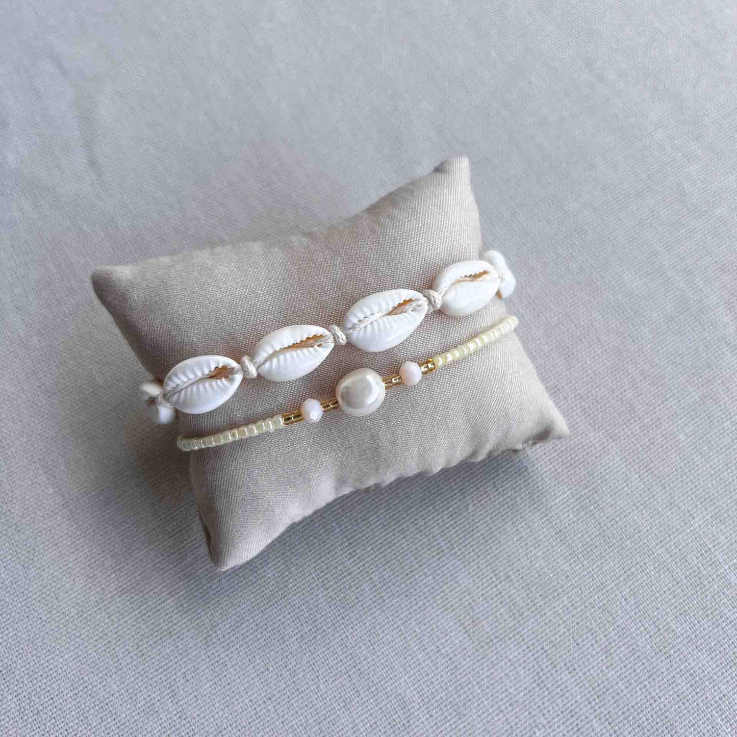 Beige armbandje met kralen om een kussentje heen