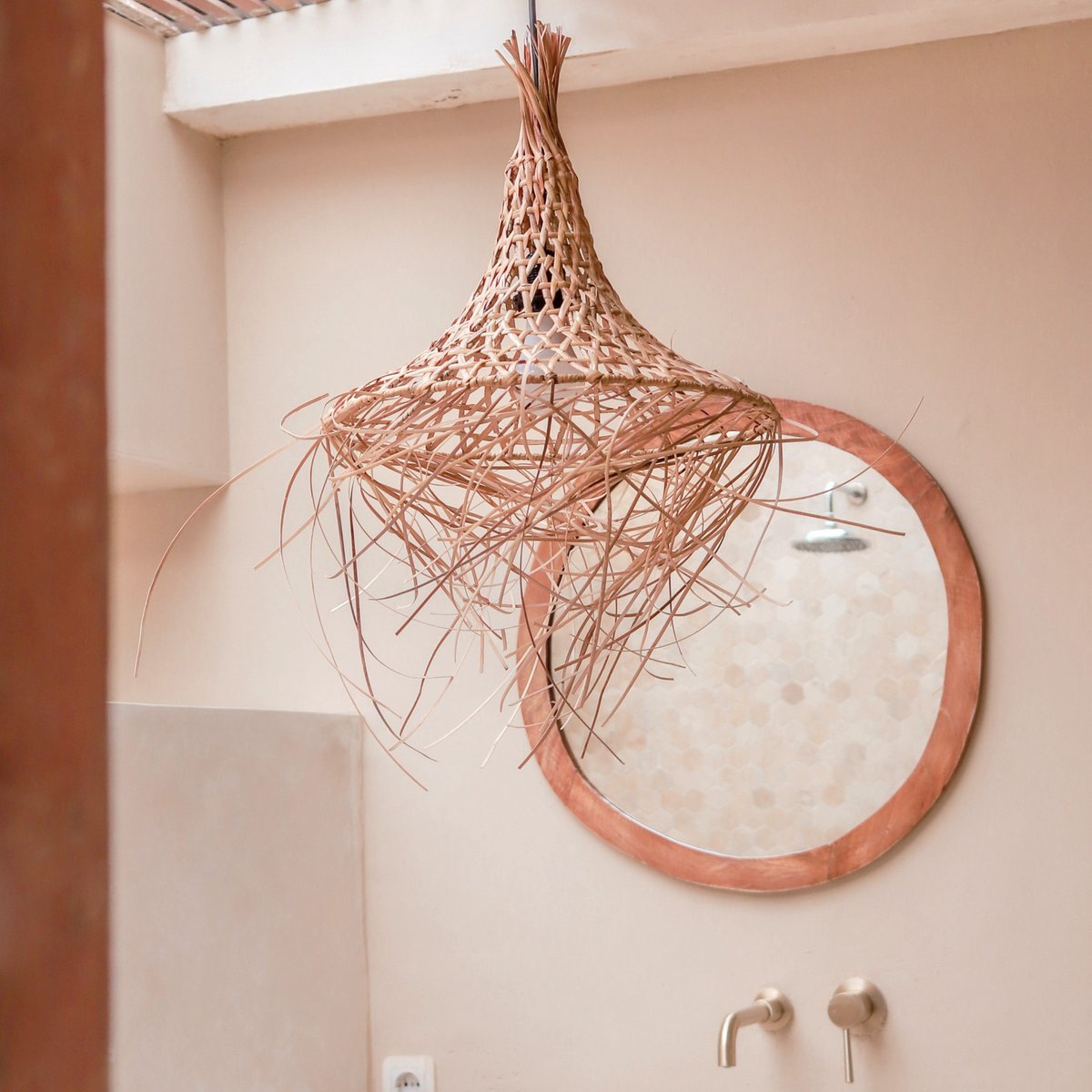 Hanglamp van bamboe met daarachter een spiegel