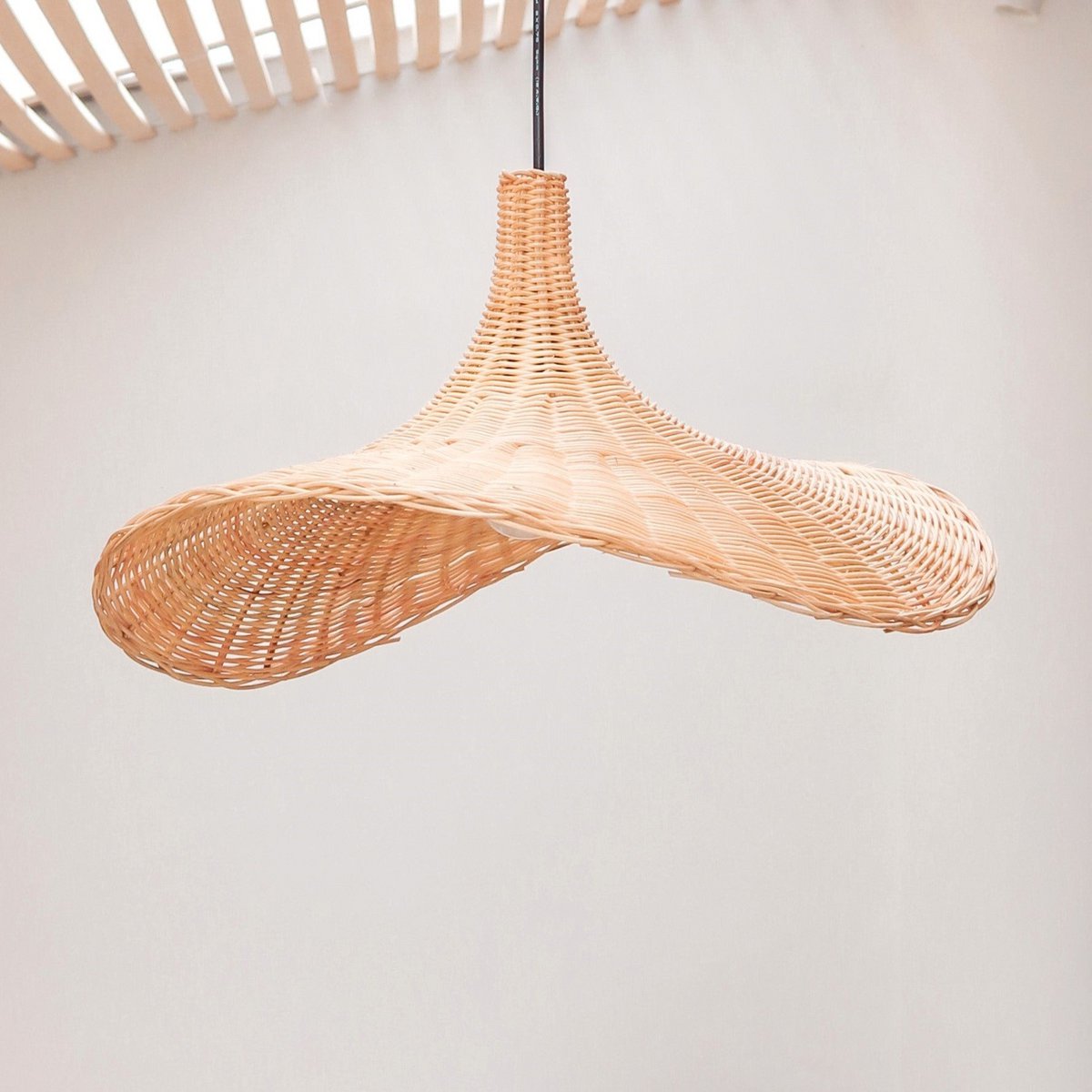 Hanglamp van rotan voor een witte muur