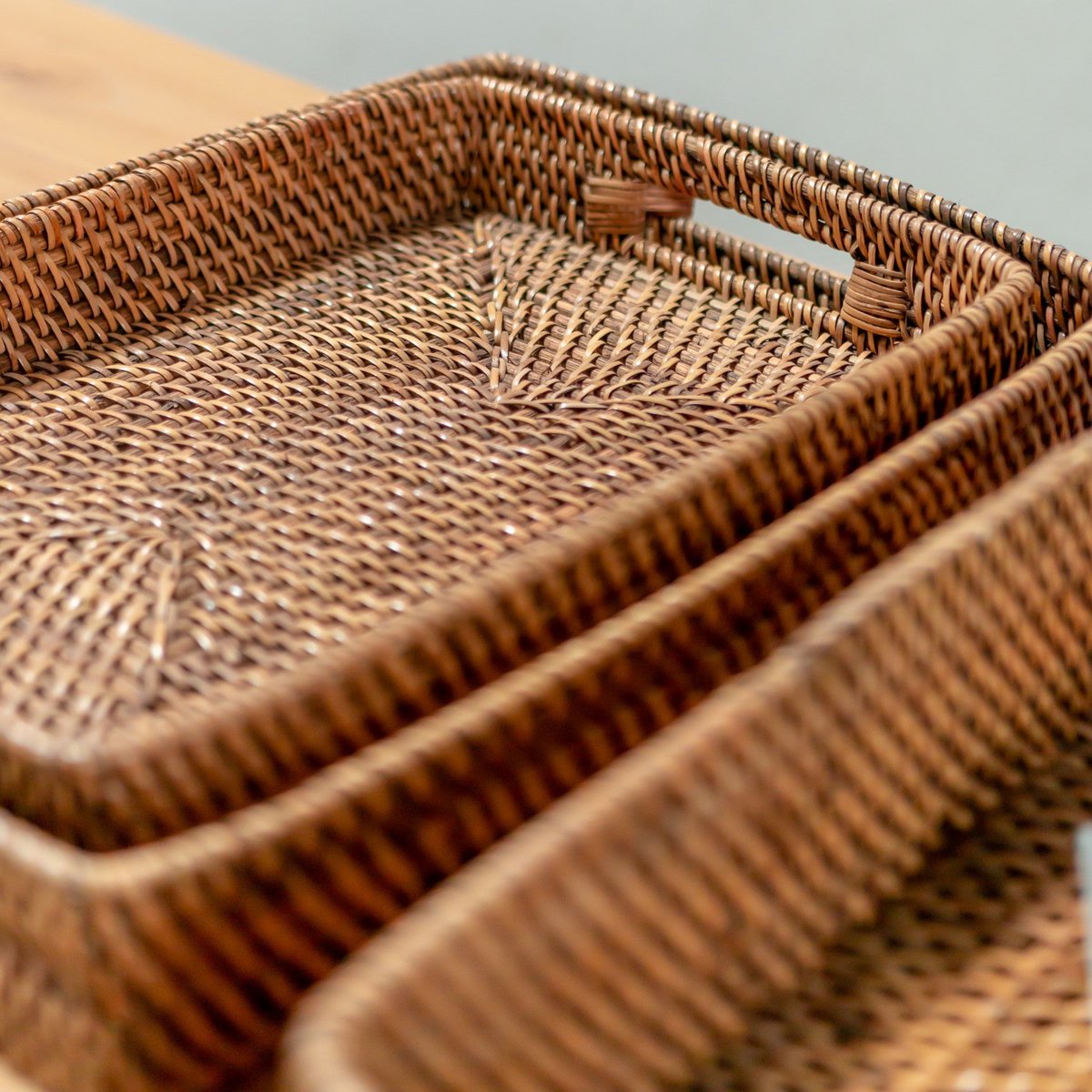 Close-up set van drie dienbladen van rotan met handvaten