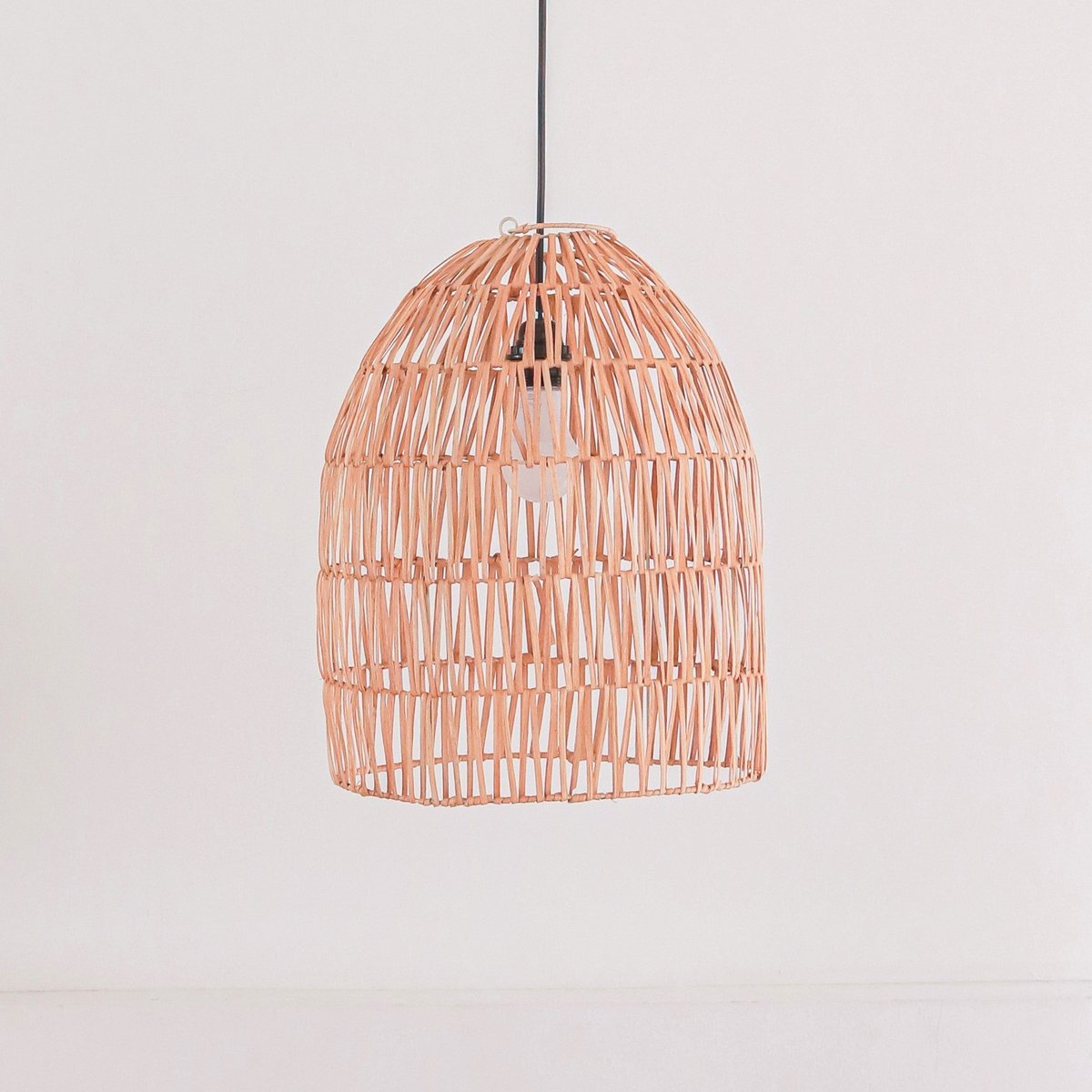 Hanglamp van rotan voor een witte muur