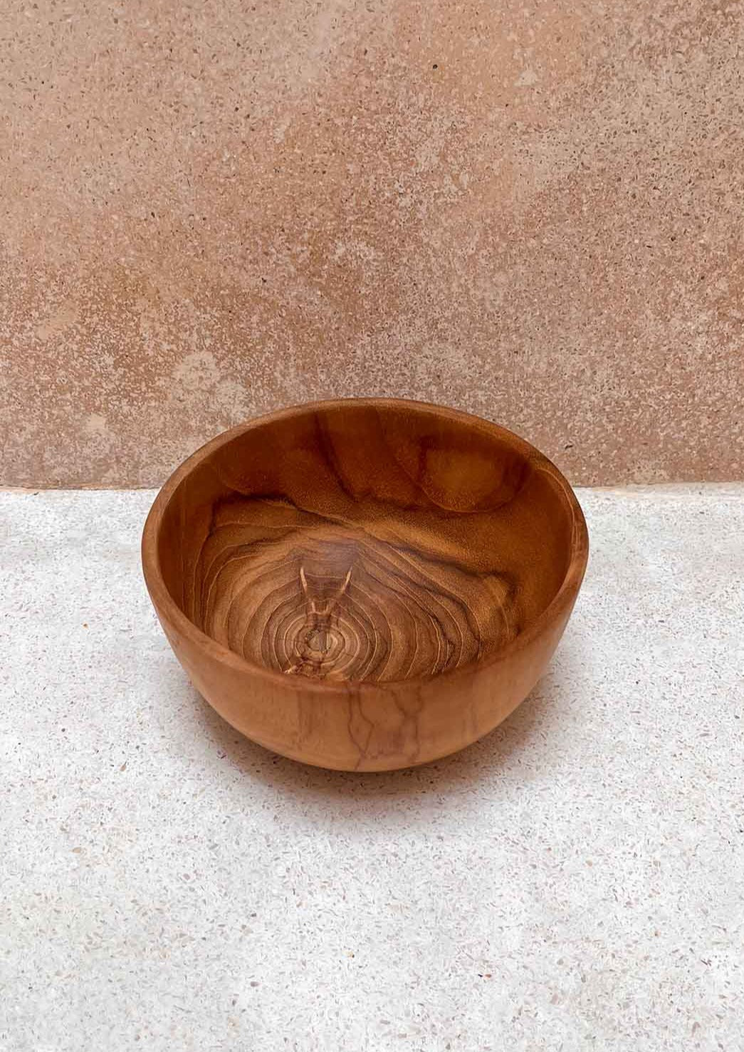 Teak houten kom op de grond voor een muur