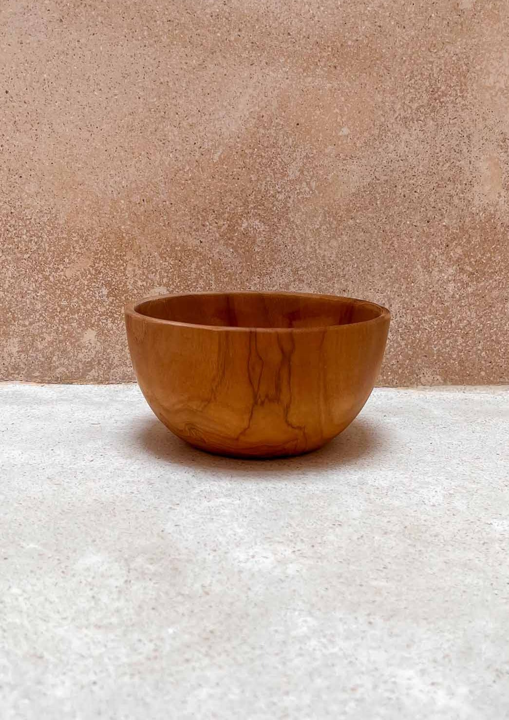 Teak houten kom op de grond voor een muur