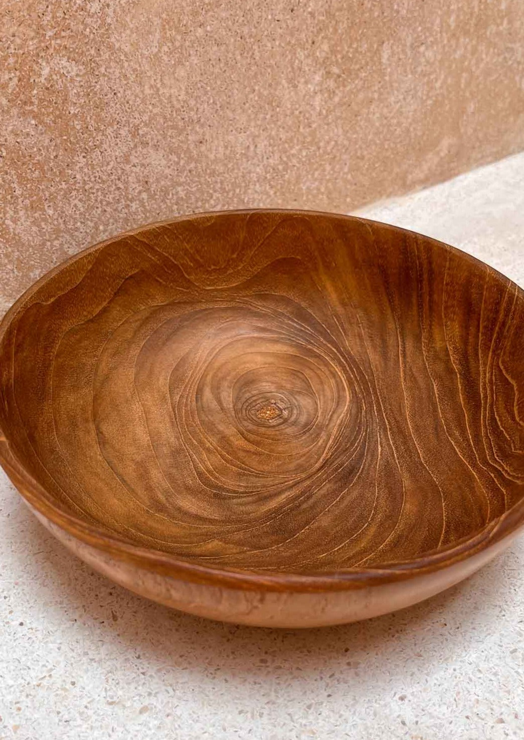 Houten kom voor een muur van dichtbij