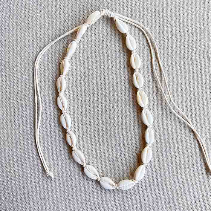 Ketting met kauri schelpjes op een zijden doek