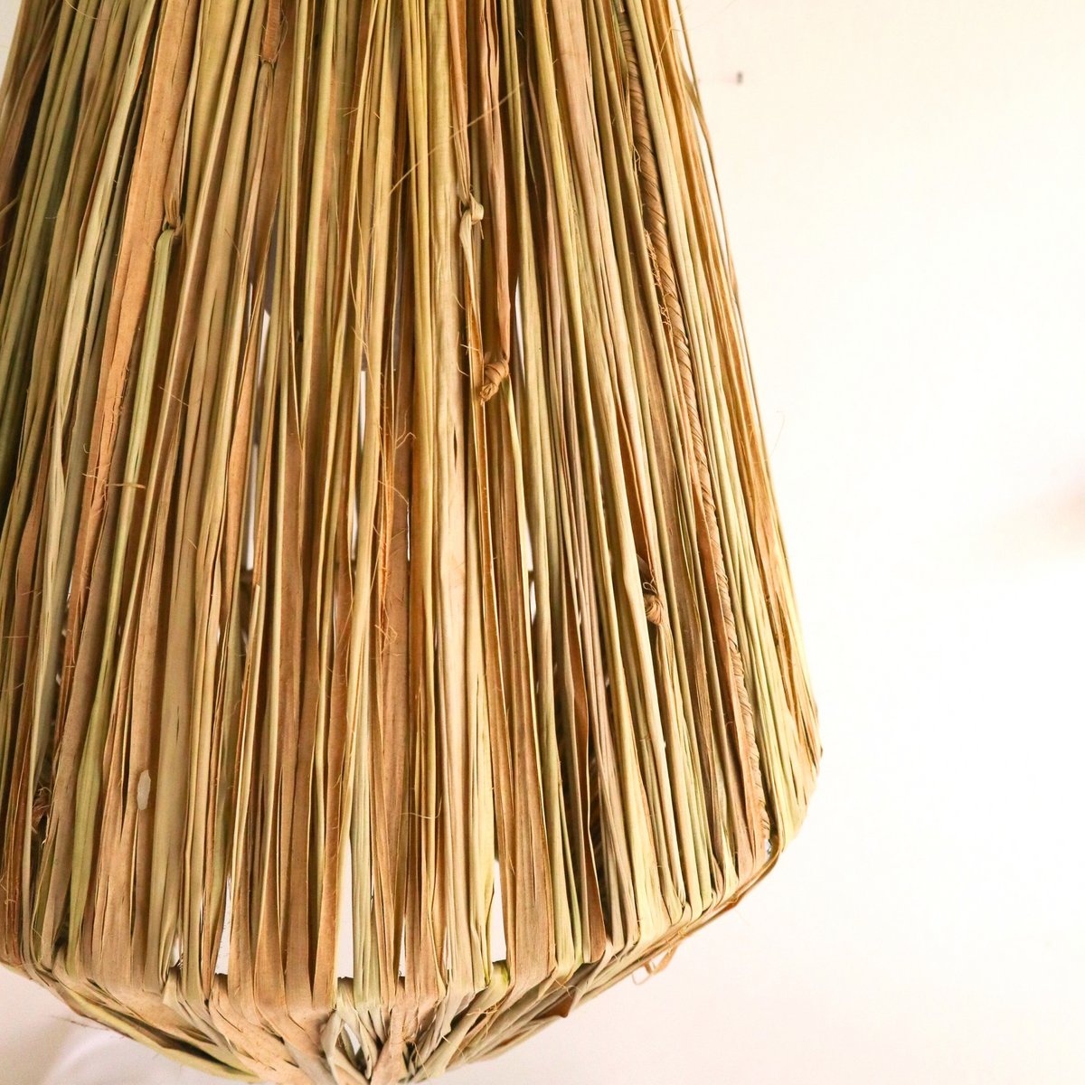 Lampenkap van raffia op een witte achtergrond van dichtbij gezien