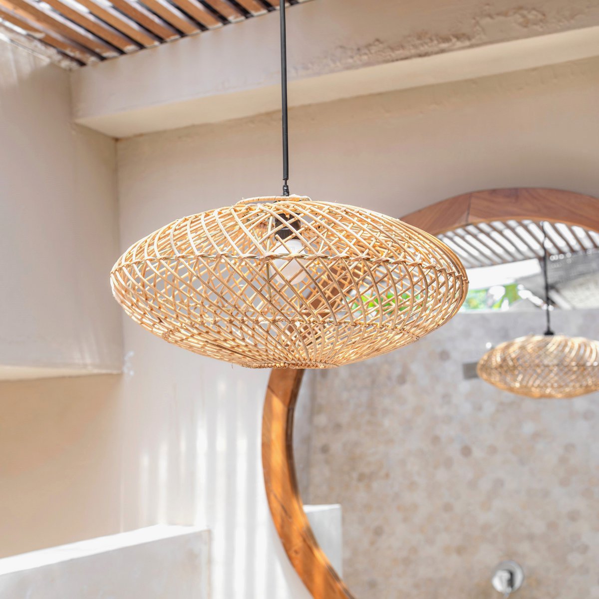 Lampenkap van rotan met een spiegel en witte muur op de achtergrond