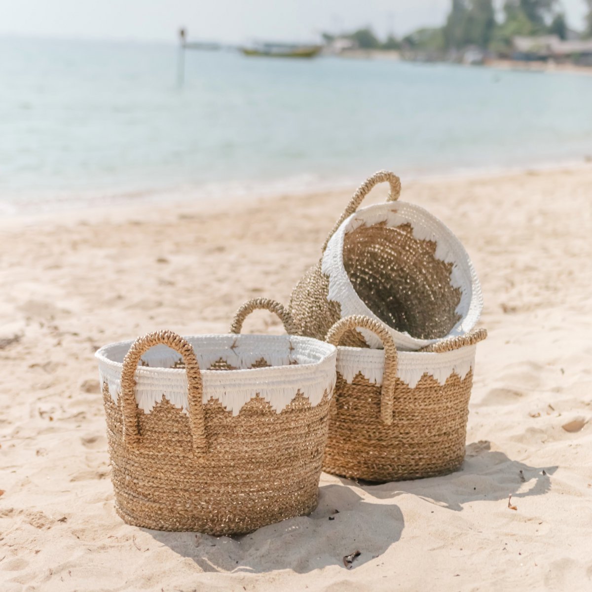 Drie opbergmanden van zeegras en katoen op het strand