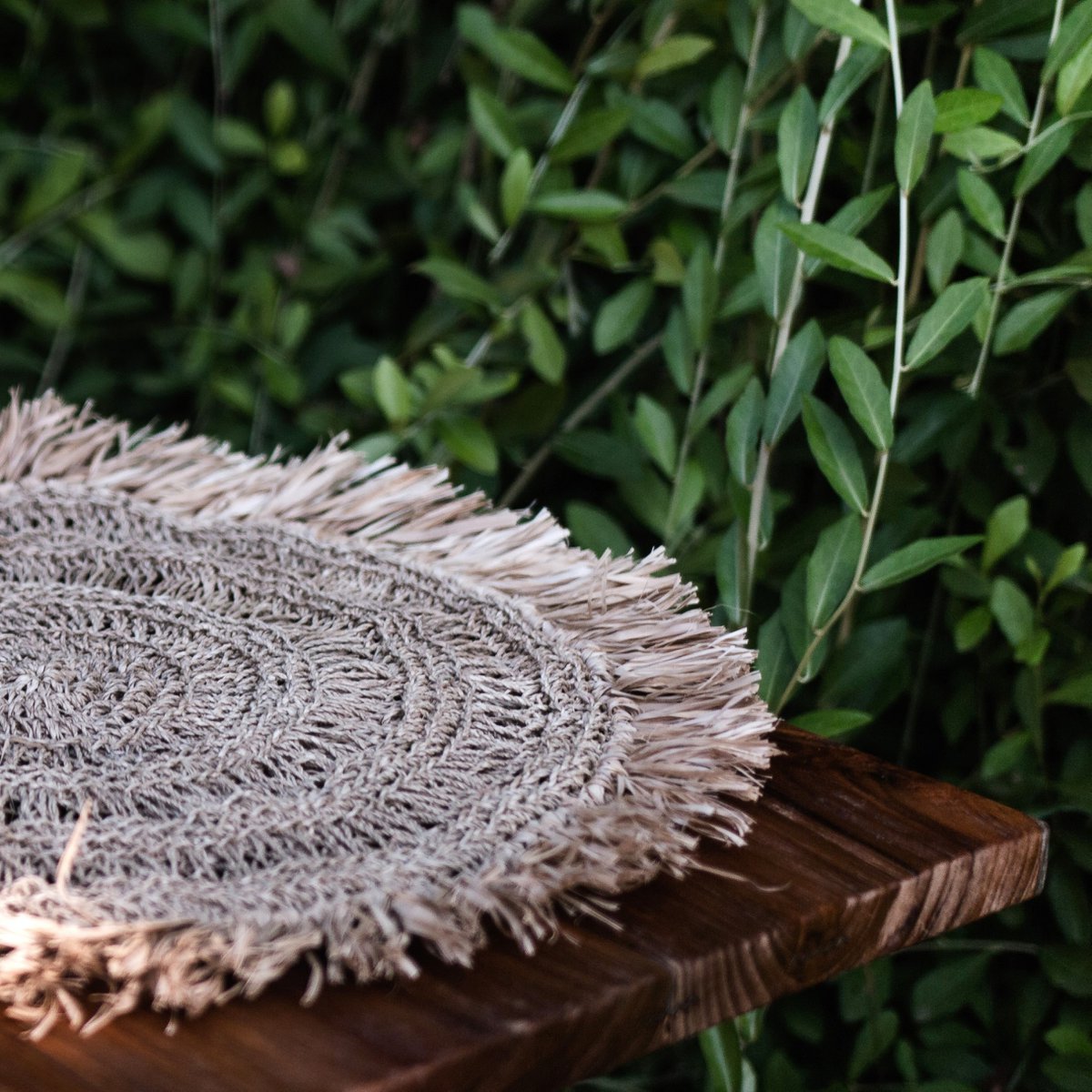 Placemat van raffia op een houten bankje van dichtbij gezien