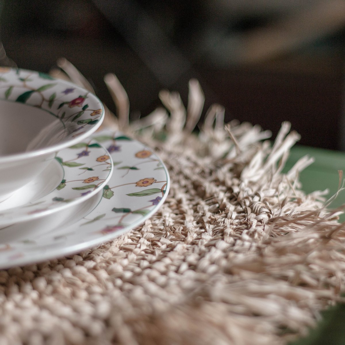 Placemat van raffia met een bord erop van dichtbij gezien