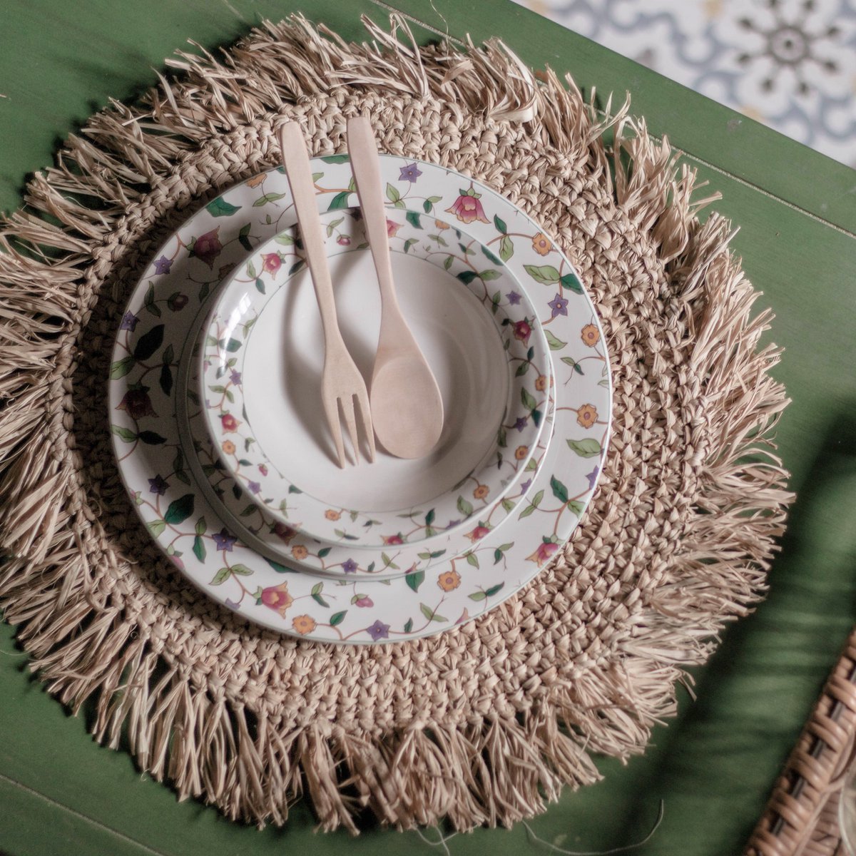 Placemat van raffia met een bord erop van boven gezien