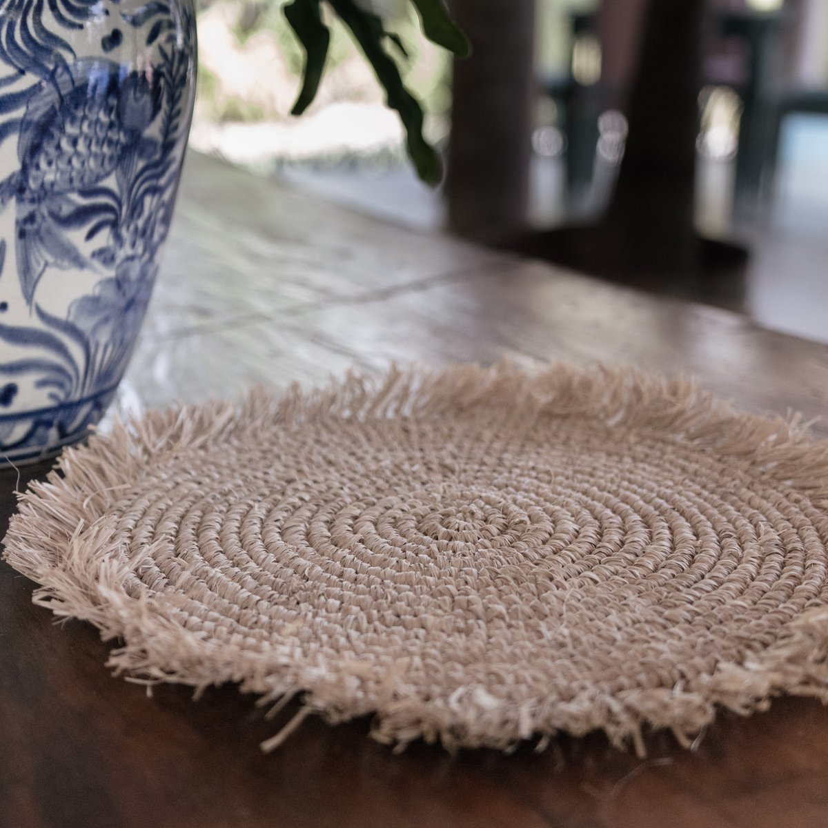 Placemat van raffia op houten tafel van dichtbij gezien