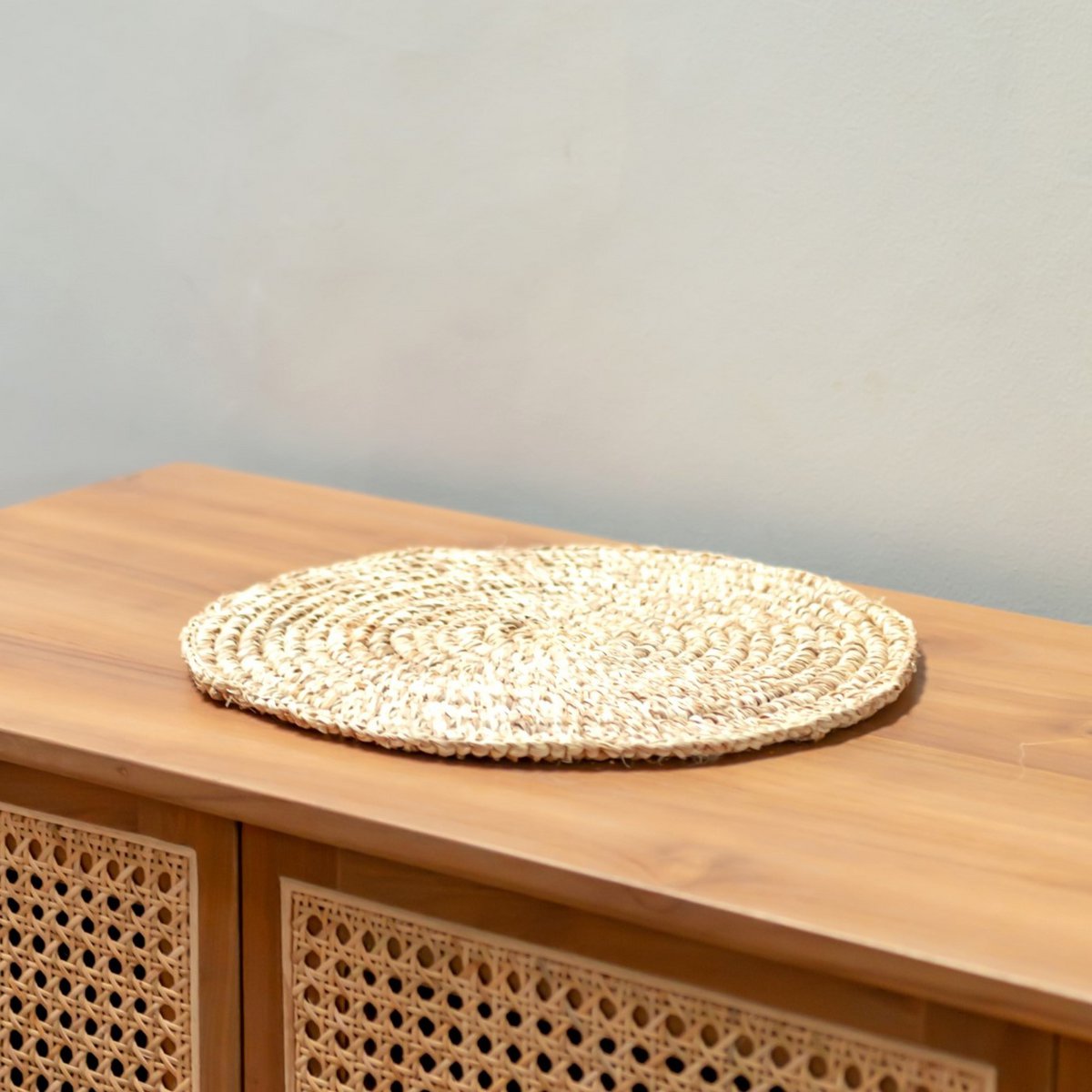 Placemat van raffia op een houten sidetable