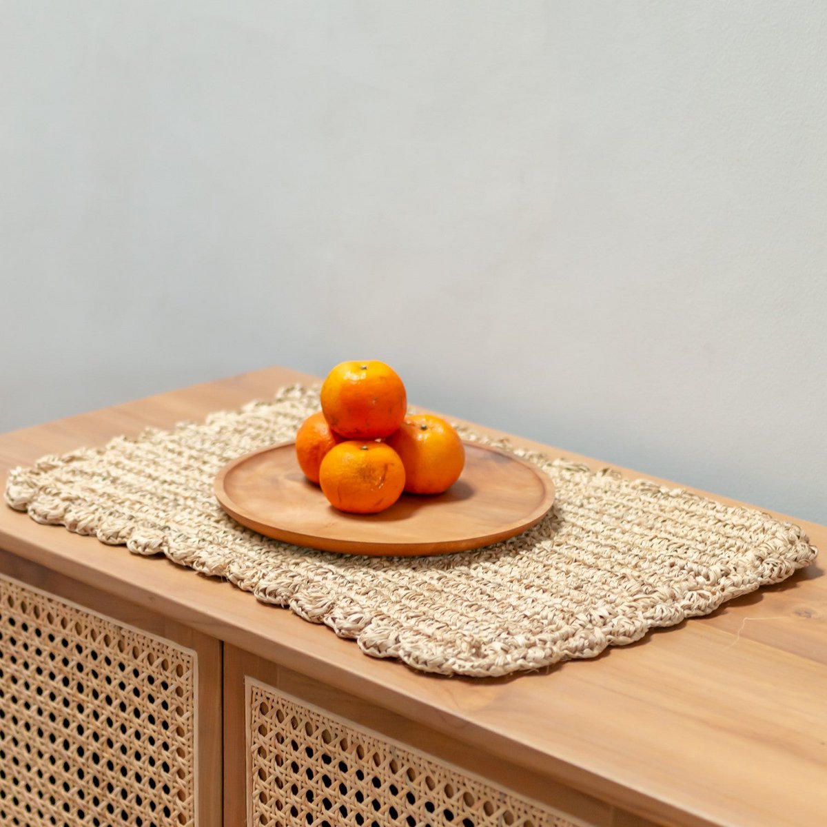 Placemat van duurzaam gevlochten raffia met een fruitschaal