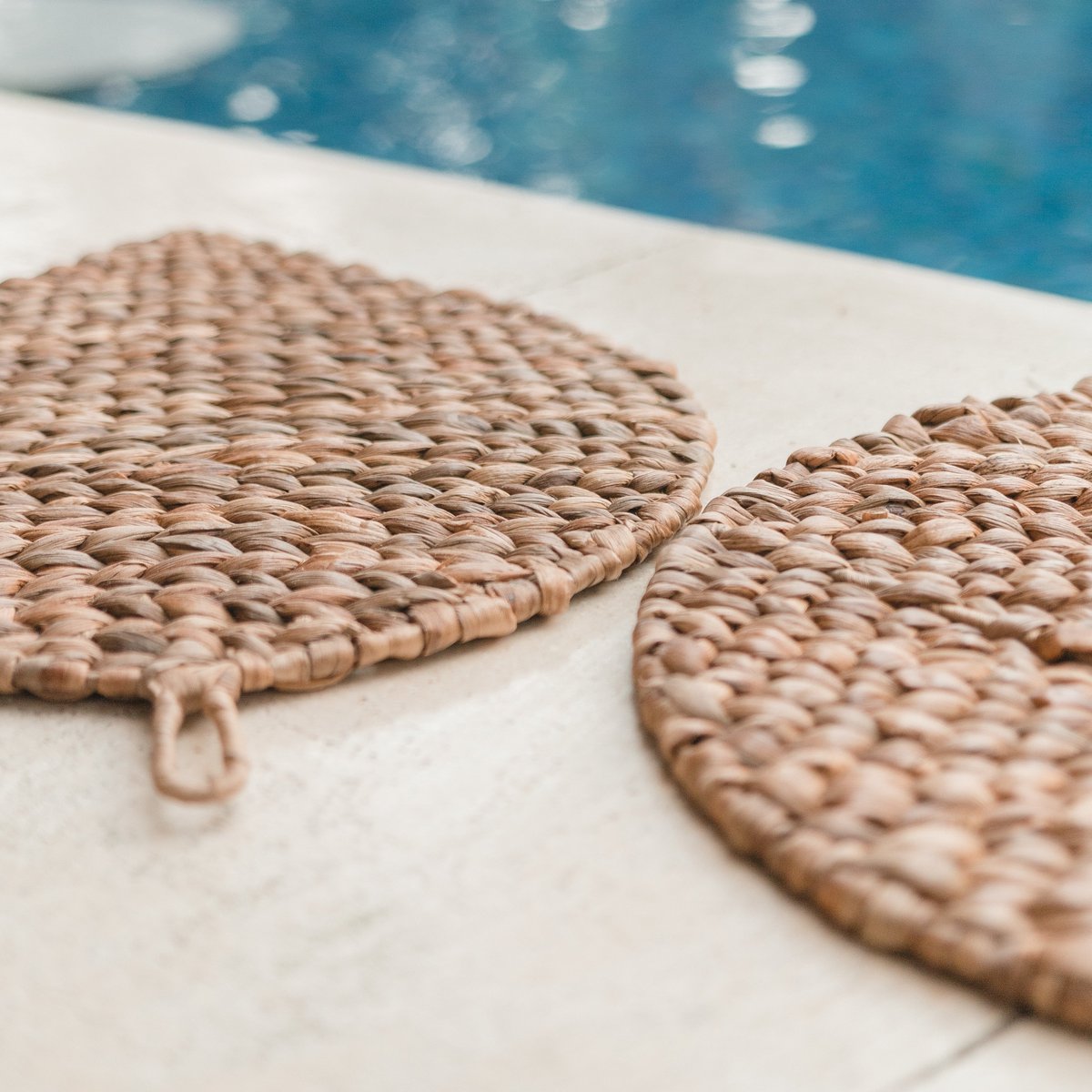 Placemat van waterhyacint op de grond naast een zwembad