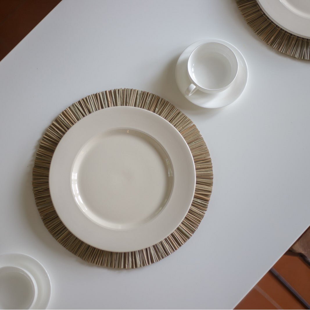 Placemat van zeegras op een witte tafel met een bord erop