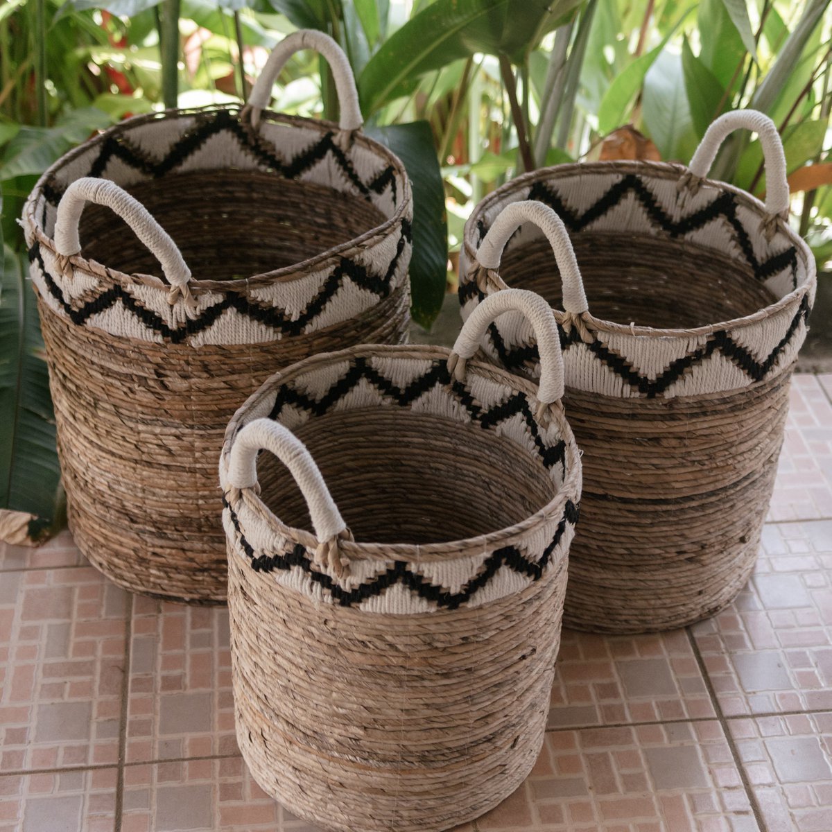 Drie plantenmanden van bananenvezel met planten erachter