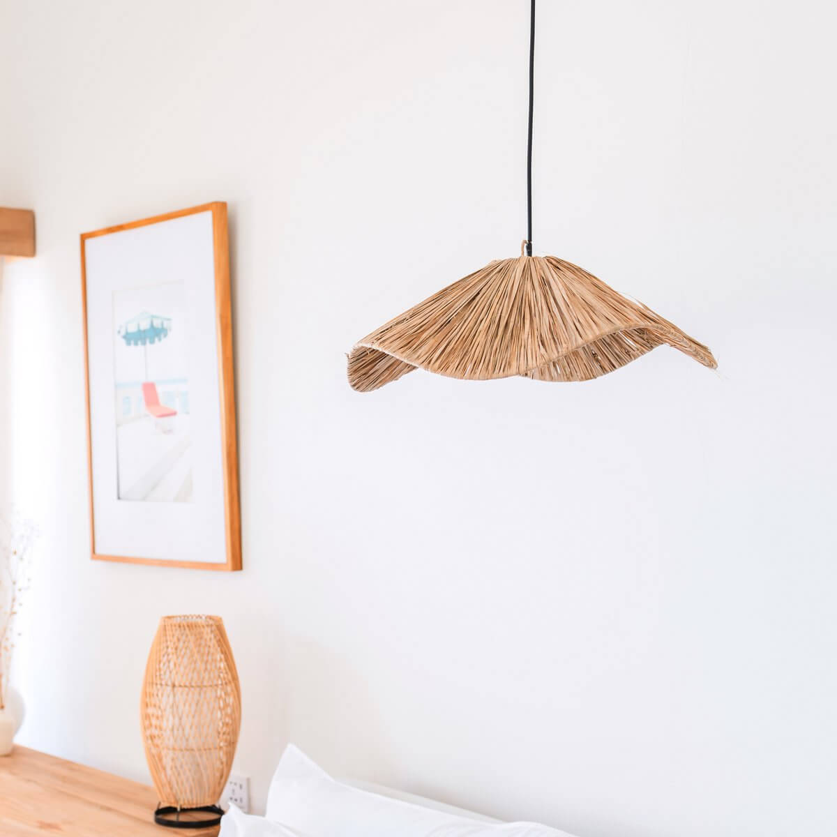 Raffia lampenkap hangend voor een witte muur