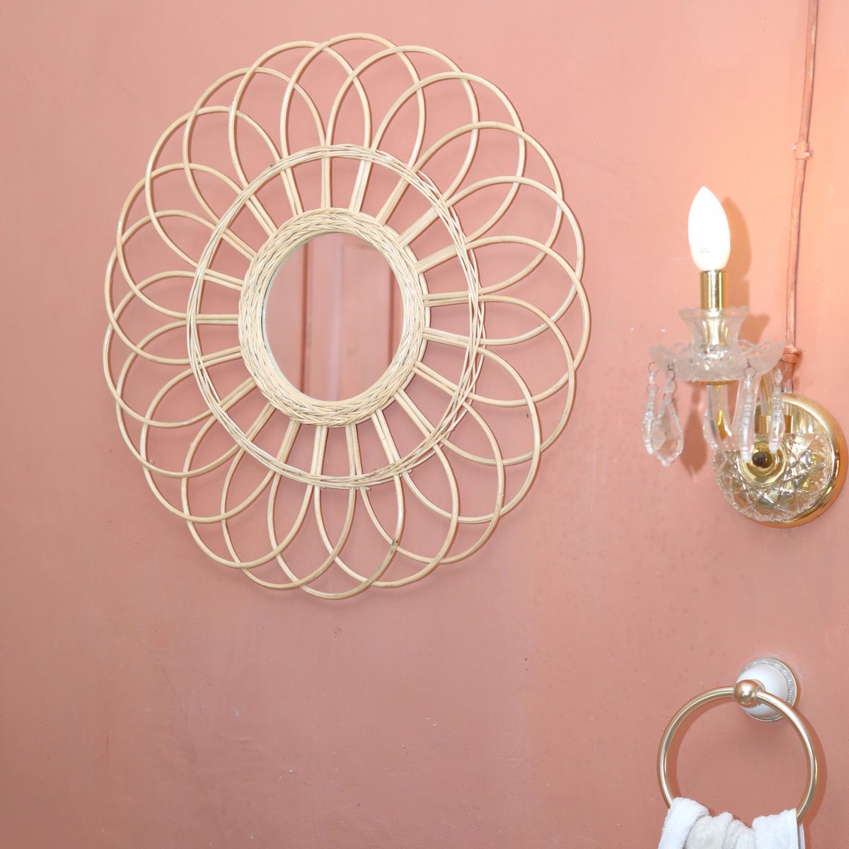 Wandspiegel van rotan op een roze muur