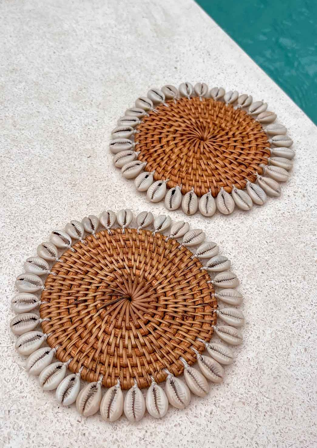 Twee schelpen onderzetters naast een zwembad