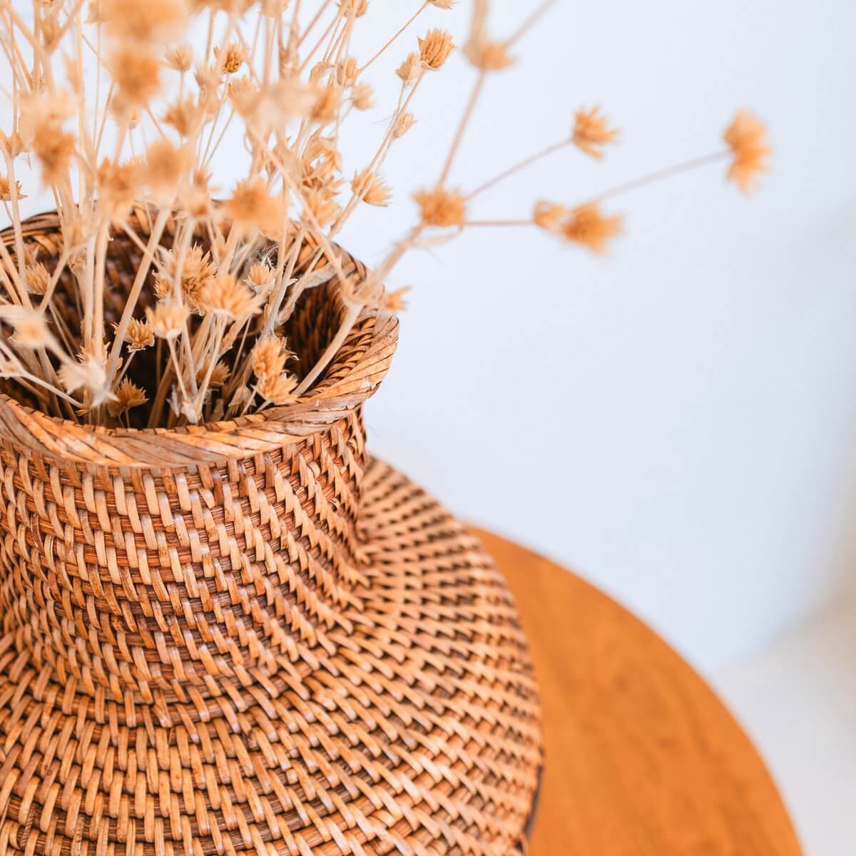 Vaas van rotan en hout met bloemen erin bovenkant van dichtbij gezien