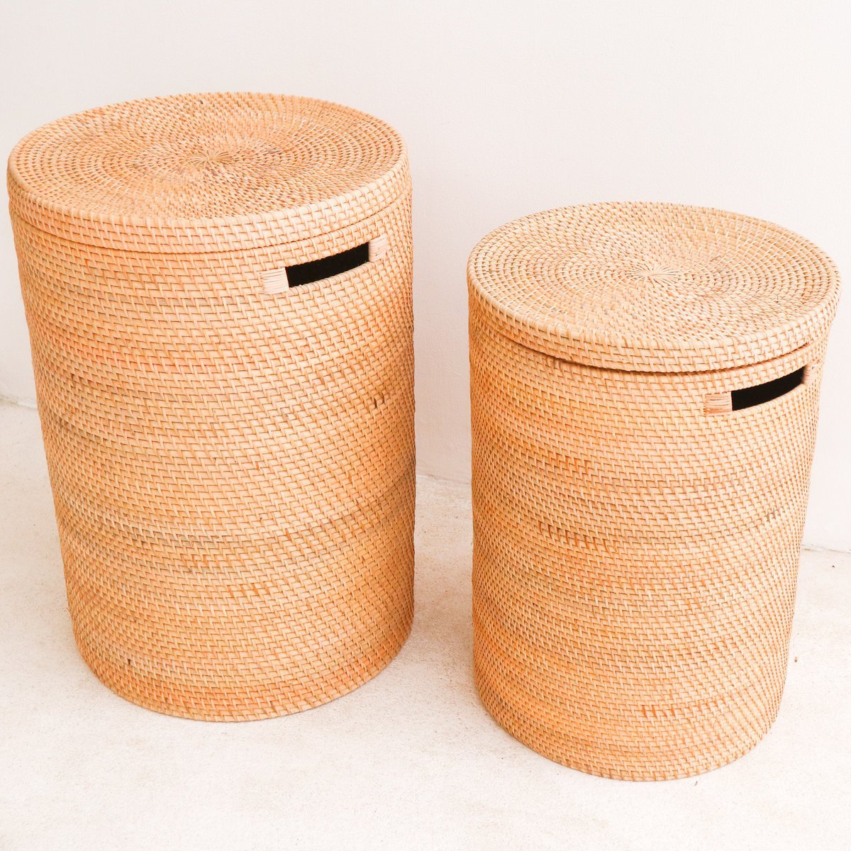 Twee rotan wasmanden met deksel naast elkaar op een witte achtergrond