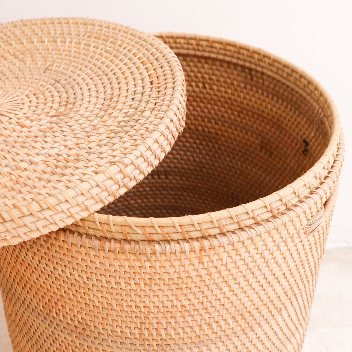 Ronde rotan wasmand met deksel er haf op vanaf boven gezien