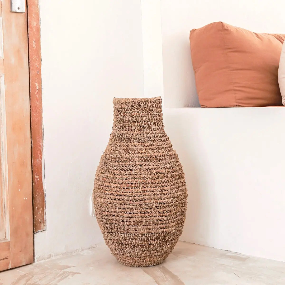 Vaas van bananenvezel en raffia voor een beige muur