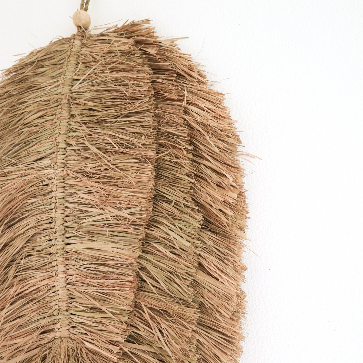 Wandhanger van handgeweven raffia ingezoomd
