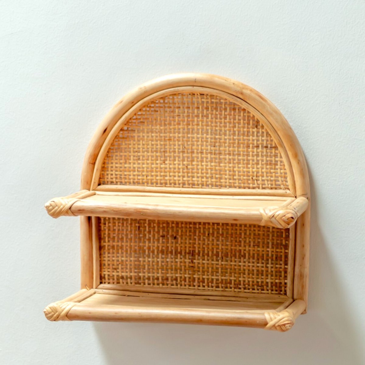 Wandplank van rotan aan een witte muur