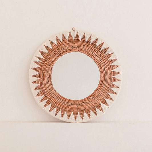 Wandspiegel van bananenvezel staand op een wit muurtje