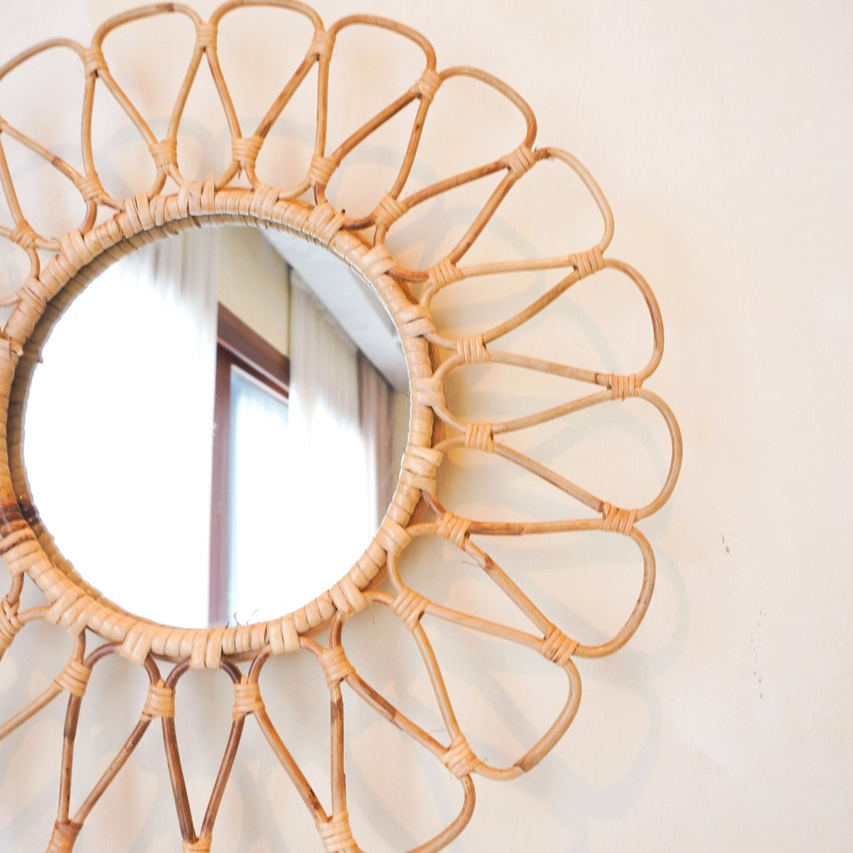 Wandspiegel van rotan op een beige muur