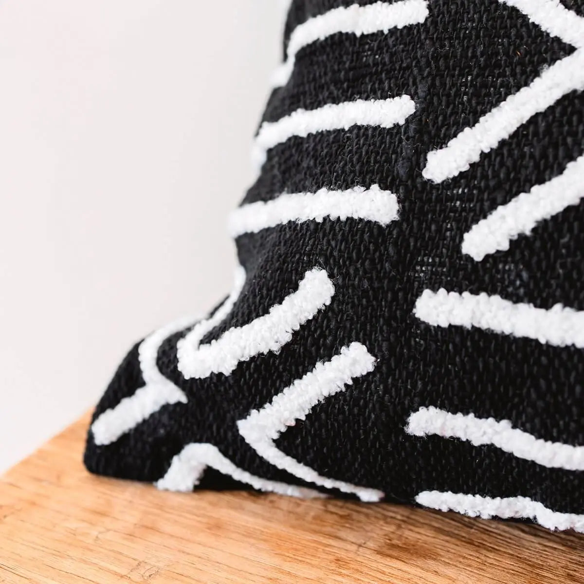 Zwarte katoenen kussenhoes met witte strepen van dichtbij gezien