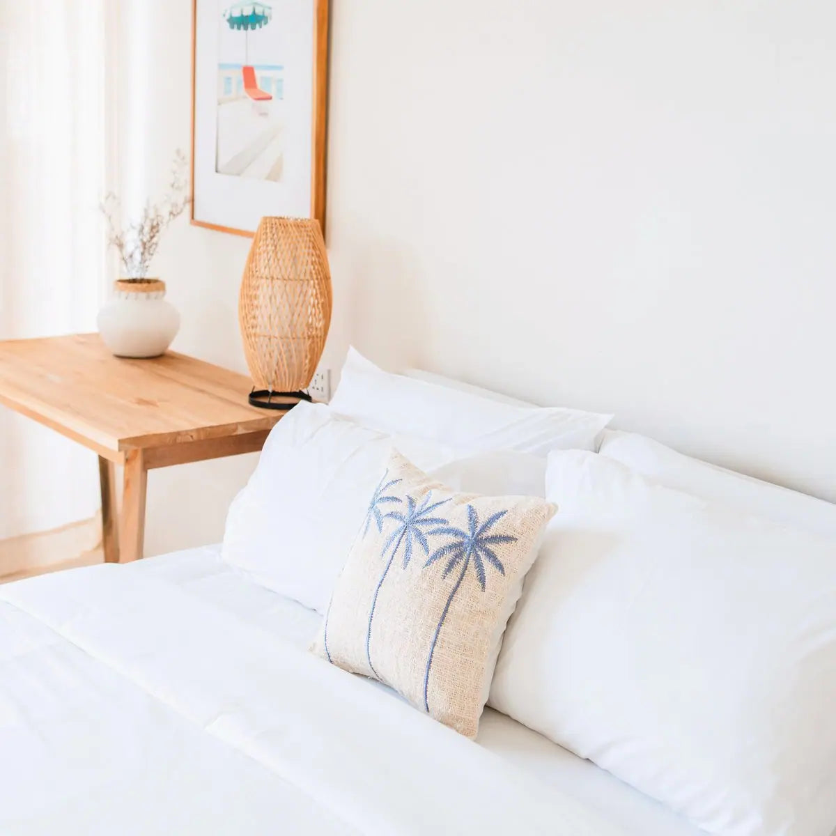 Katoenen kussenhoes met daarop drie palmbomen op een bed 