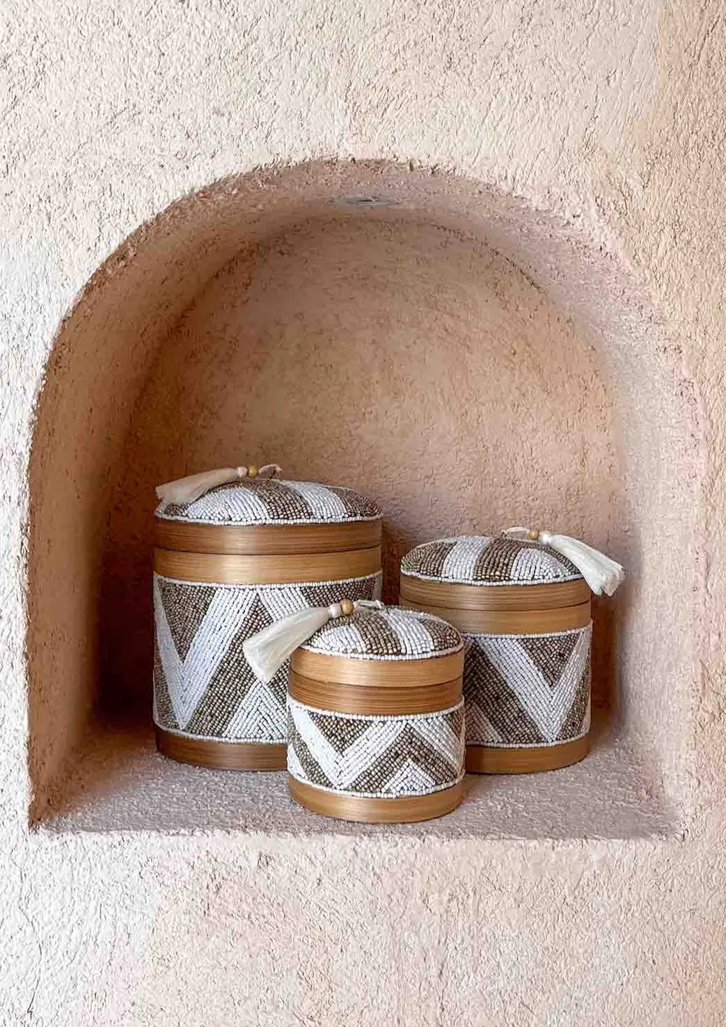 Drie offermandjes, klein, middel en groot staand in een inkeping in een muur