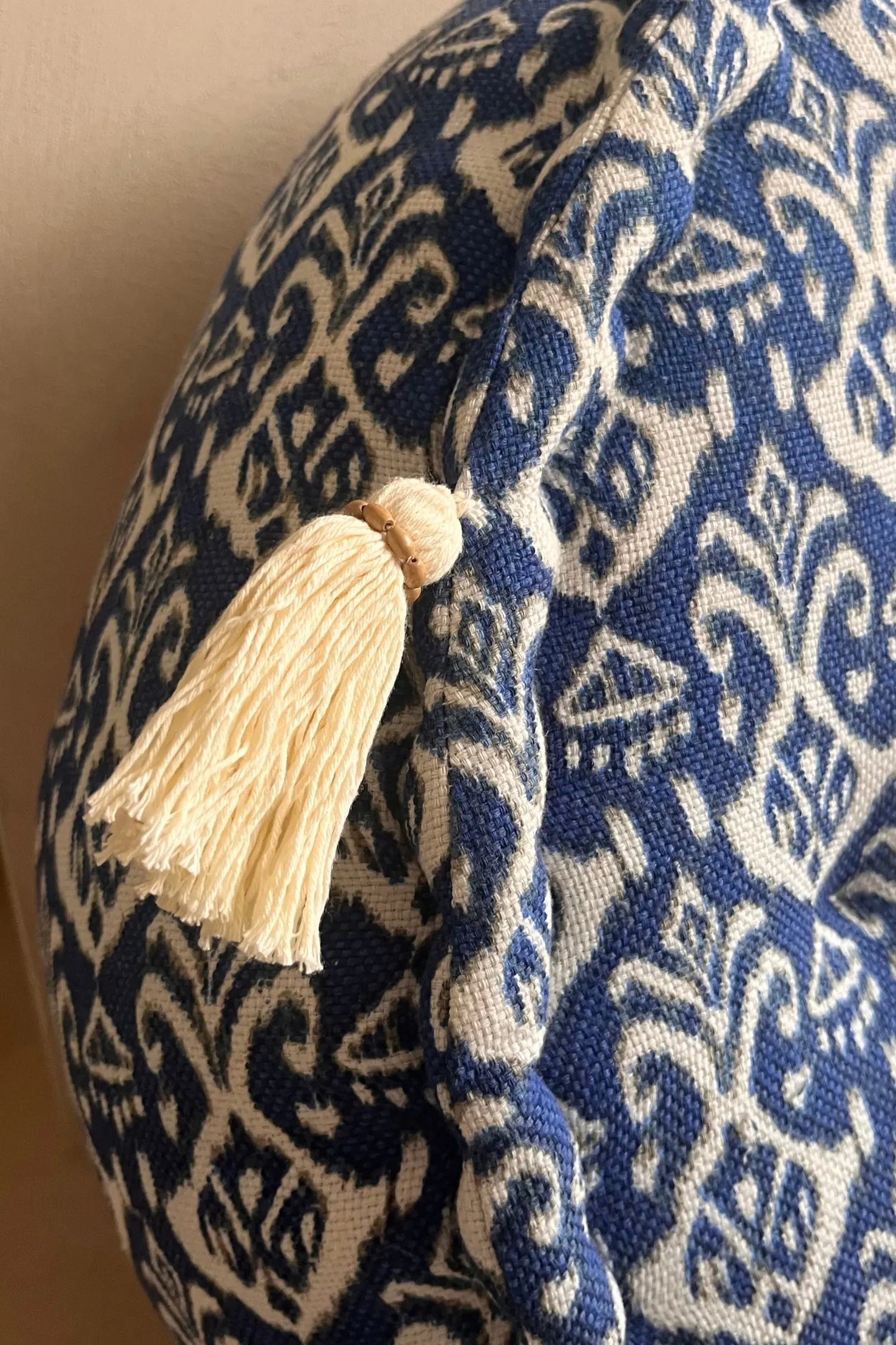 Ronde blauw witte poef van katoen met beige franjes van dichtbij gezien