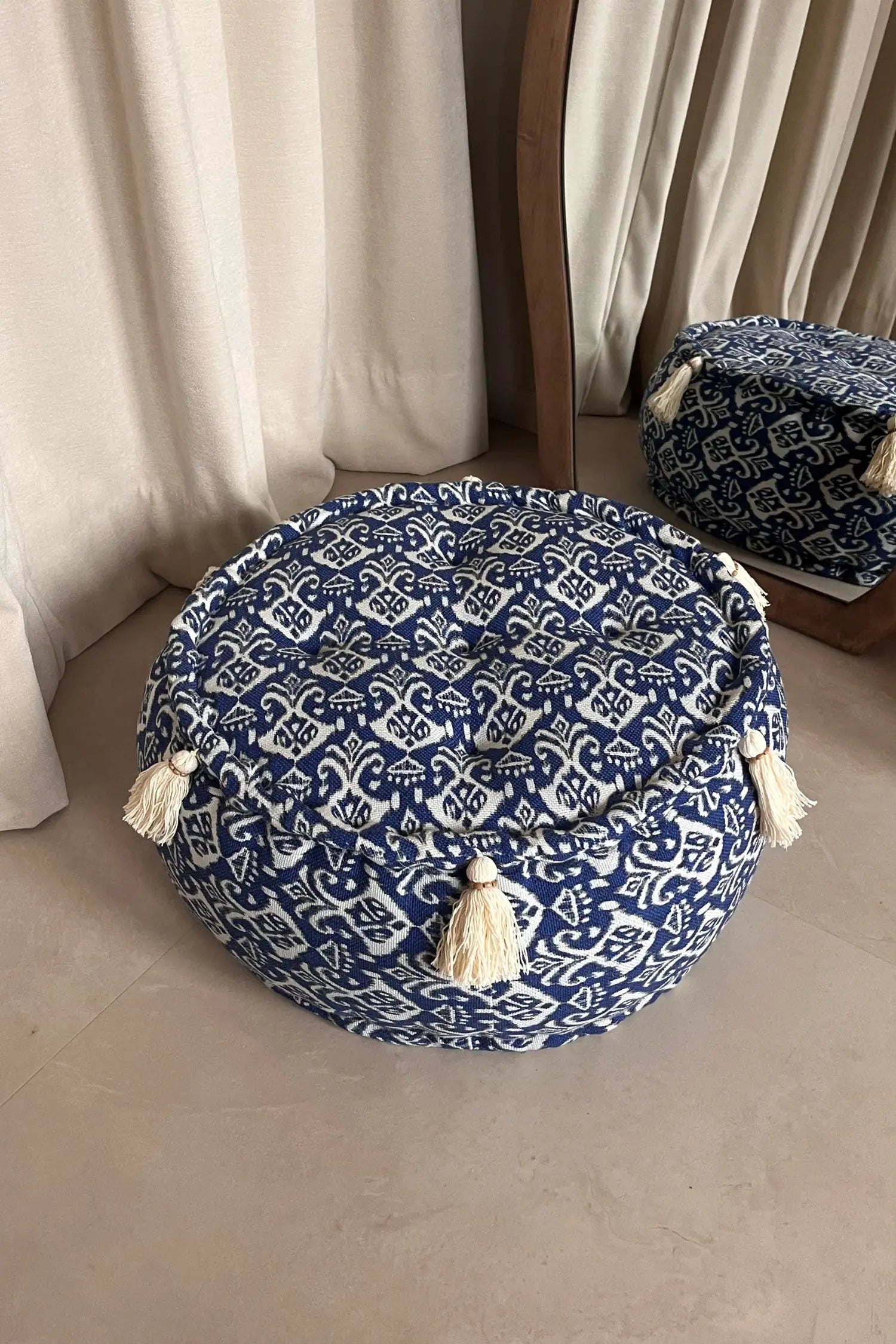 Ronde blauw witte poef van katoen met franjes voor een spiegel