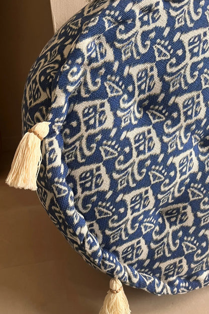 Ronde blauw witte poef met franjes en knopen schuin van dichtbij gezien 