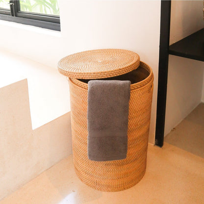 Rotan wasmand met de deksel half erop en een handdoek erin