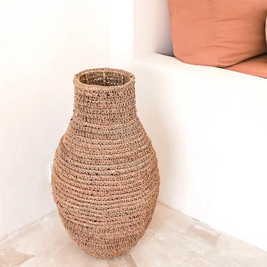 Vaas van bananenvezel en raffia voor een witte muur