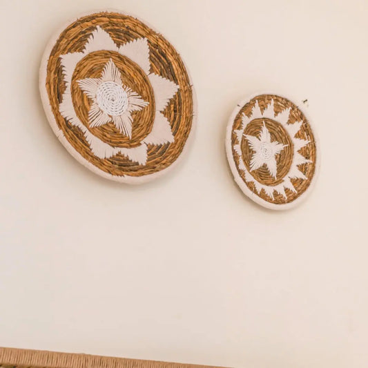 Wanddecoratie van bananenvezel hangend aan een witte muur 