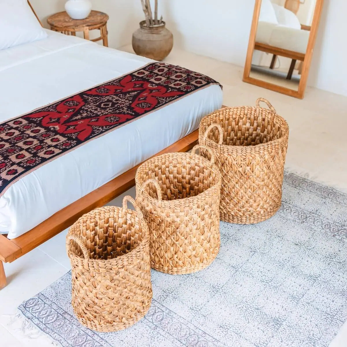 Drie waterhyacint manden van verschillende maten achter een bed